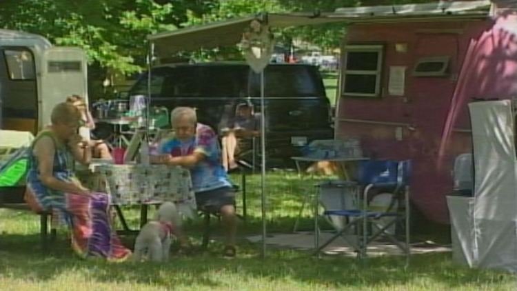 A couple sits outside their trailer; Long Beach, July 12, 2014