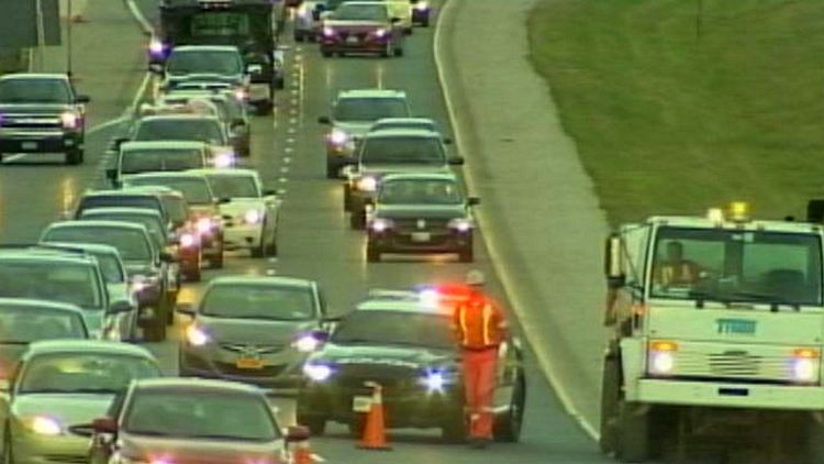 Traffic diverts around a cleanup crew after a gravel spill on the northbound Red Hill Valley Parkway; Hamilton, September 9, 2014