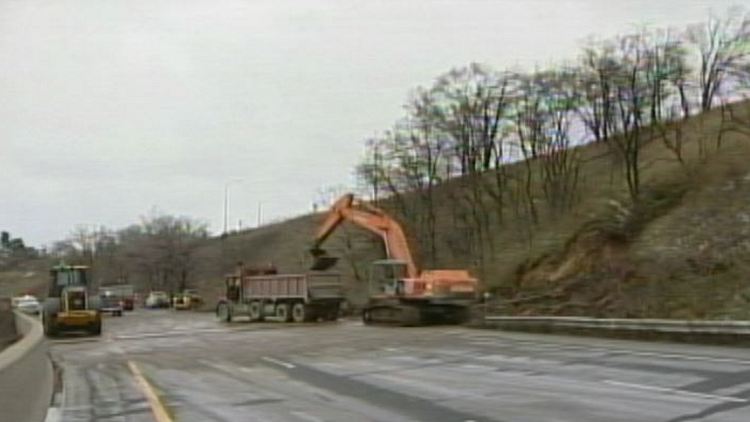 An excavator digs in to the slope beside Highway 403; Hamilton, November 28, 2014