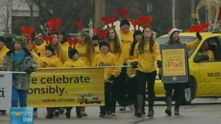 Burlington Taxi employees march in the 2013 Burlington Santa Claus parade