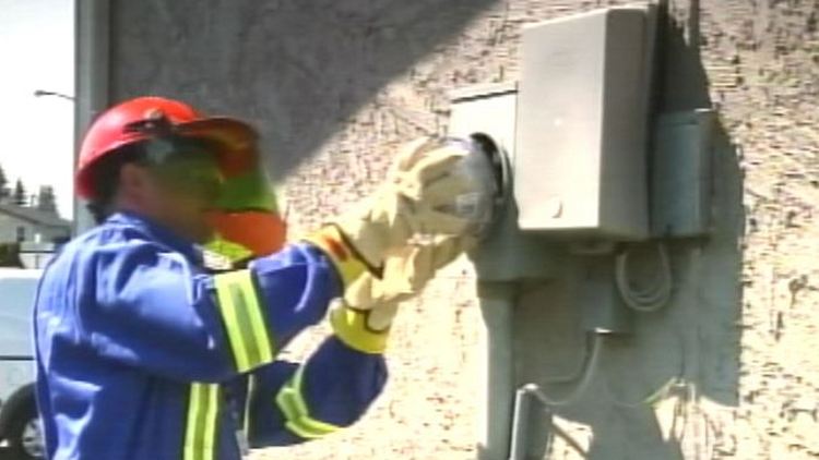 An electricity utility worker installing a power meter (archive image)