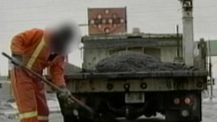 A city of Hamilton worker shovels asphalt from a works truck (archive image)