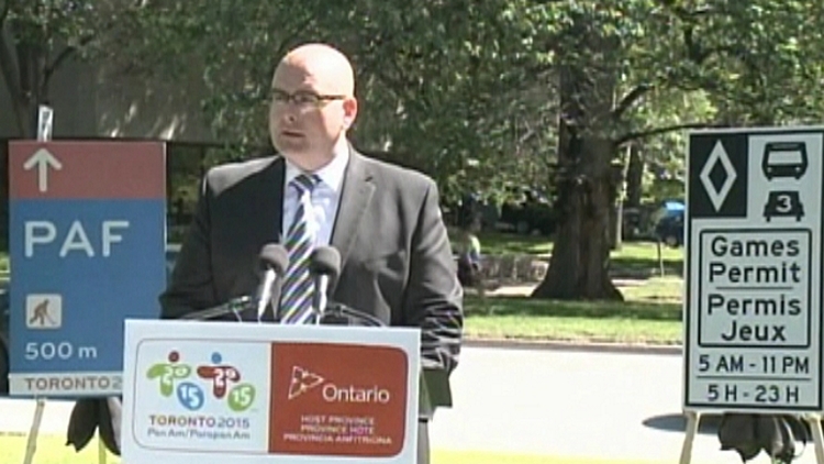 Ontario transportation minister Steven Del Duca in front of special highway signs for the Pan Am games; Queen's Park, June 23, 2015