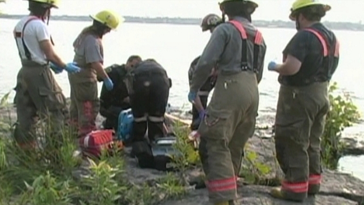 Fire crews work on a man pulled out of the Niagara River; Fort Erie, July 6, 2015