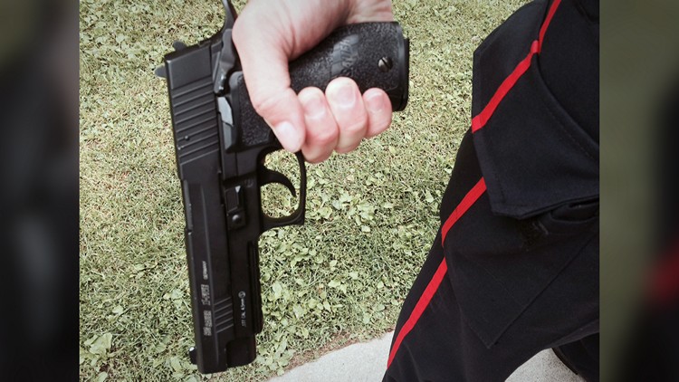 A police officer holds a replica pellet gun (undated)