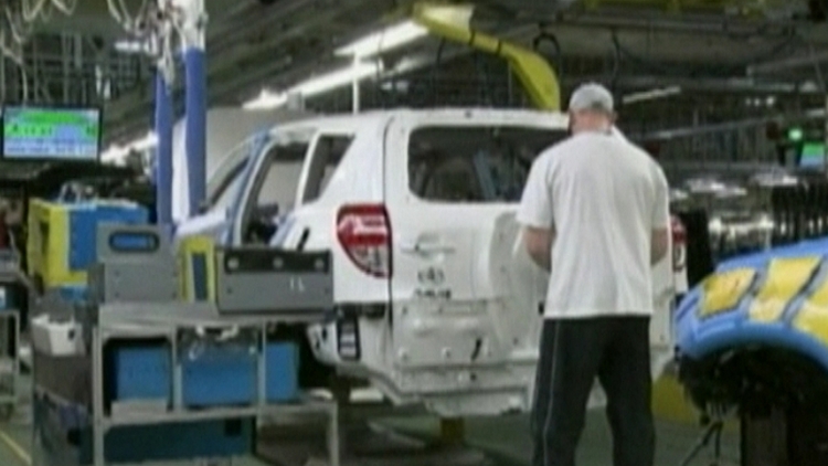 A worker looks after a RAV4 on the Toyota assembly line