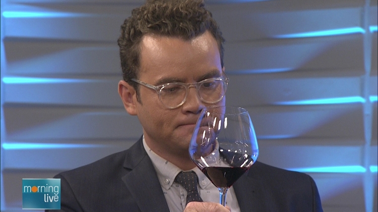 Tim Bolen contemplates the glass of red wine he has just sampled; Morning Live, September 15, 2015