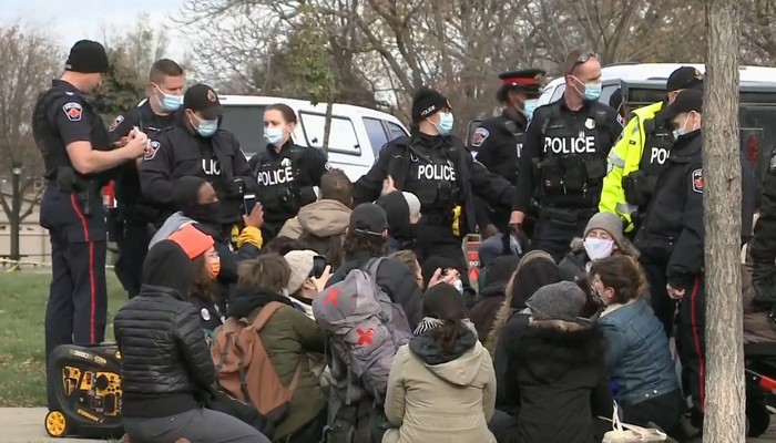 Protesters clash with police to stop the removal of encampments, hours after a fire destroyed tents