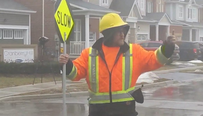 Dancing flag workers bring smiles to drivers faces while directing traffic