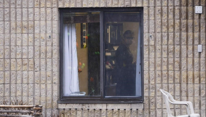 A worker is shown through a window at a long-term care home in Almonte, Ont. on Thursday, April 9, 2020.