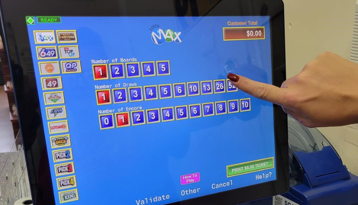 A clerk hands prints off a customer's Lotto Max ticket at a gas station north of Newcastle, Ont. on Thursday Oct. 6, 2022.