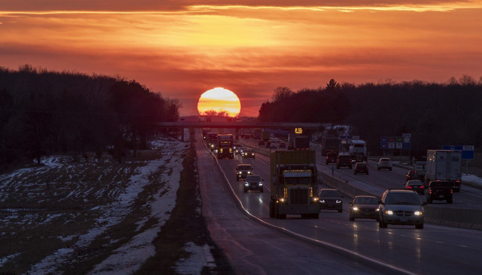 The sun sets as traffic moves along Highway 401 in Belleville, Ont., on Tuesday, December 21, 2021.