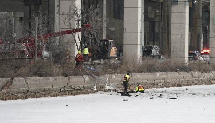 Emergency crews work to retrieve a car that crashed through the ice into the Keating Channel in Toronto on Saturday Jan. 20, 2024