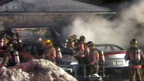 Fire crews hose down smoking cars in Deerhurst Dr driveway; Burlington, Febraury 21, 2014