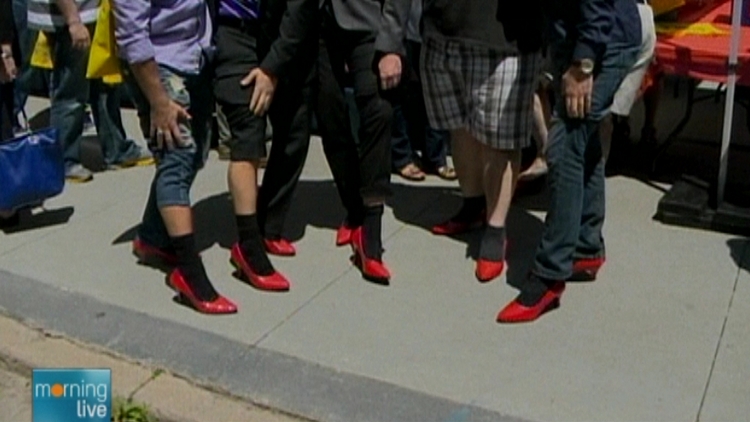 Men modeling women's heels at Walk A Mile in Her Shoes (archive image)
