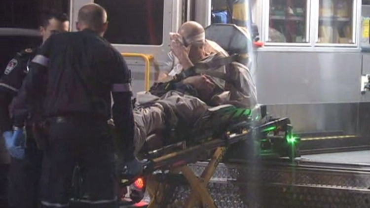 Paramedics load injured man into ambulance