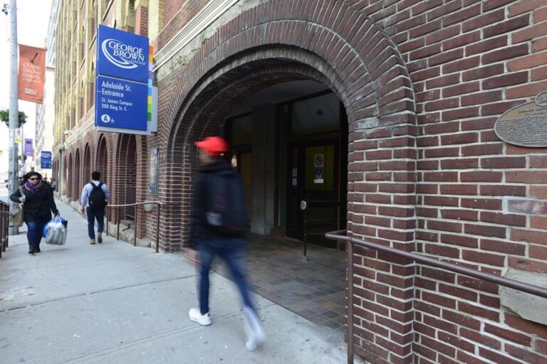 People walk near an entrance to George Brown College in Toronto on Tuesday, Nov. 21, 2017.