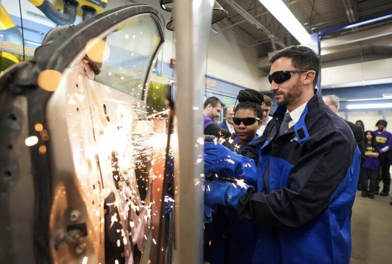 Stephen Lecce, Minister of Education, right, gets help from grade 11 student Shanaid Tomlinson, 16, as they practise plasma welding while visiting St. Mary Catholic Secondary School in Pickering, Ont., on Wednesday, March 8, 2023